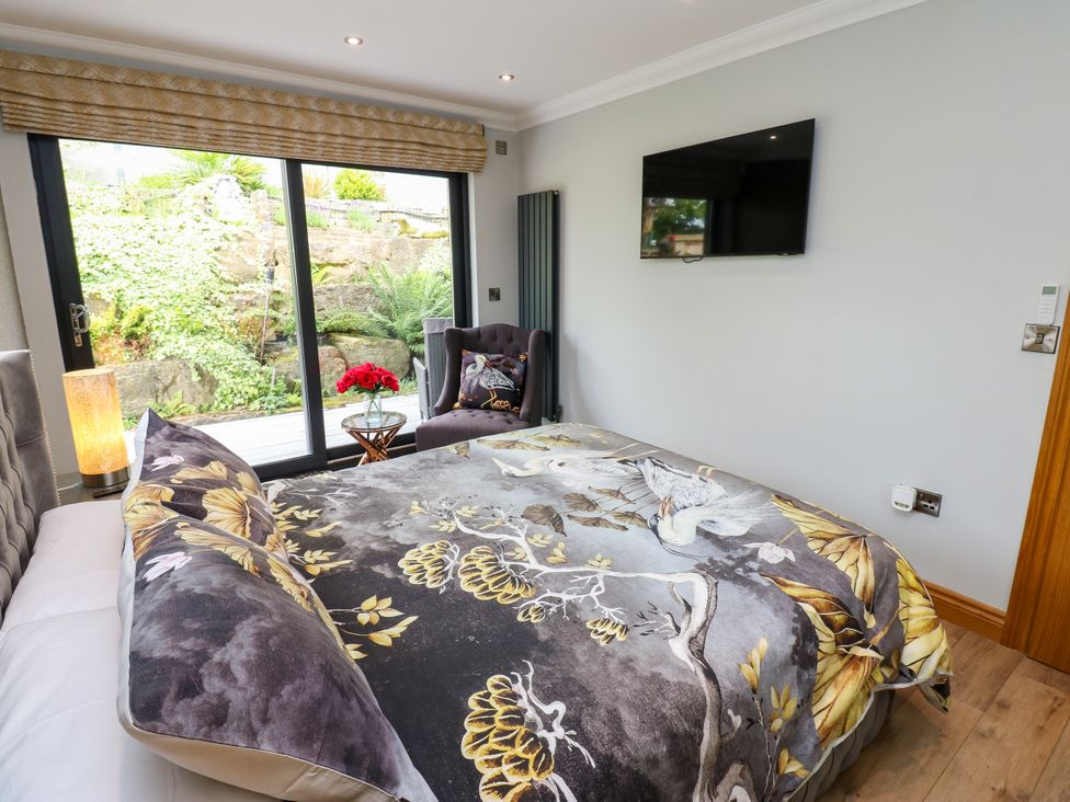 A bedroom with a bed and a television at Caesars Lodge in Houghton Bank near Heighington