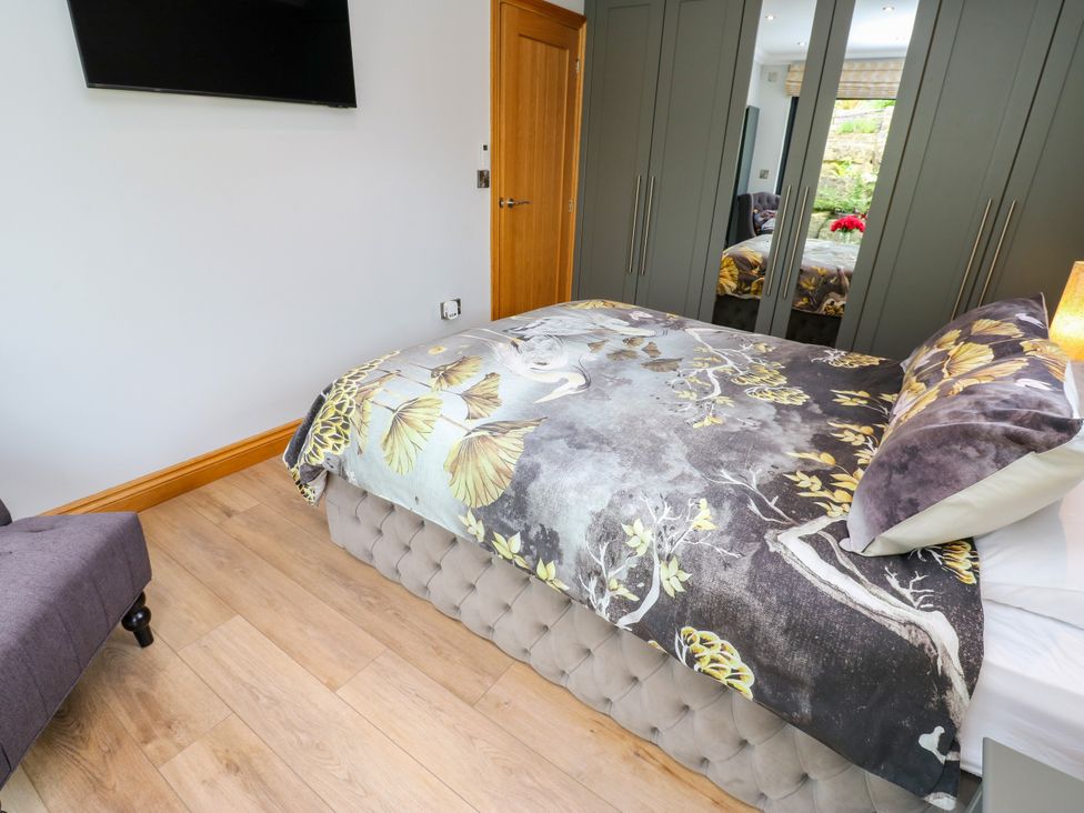 A bedroom with a bed and television at Caesars Lodge Houghton Bank near Heighington
