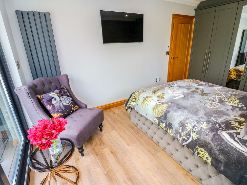 A bedroom with a bed and a chair at Caesars Lodge in Houghton Bank near Heighington