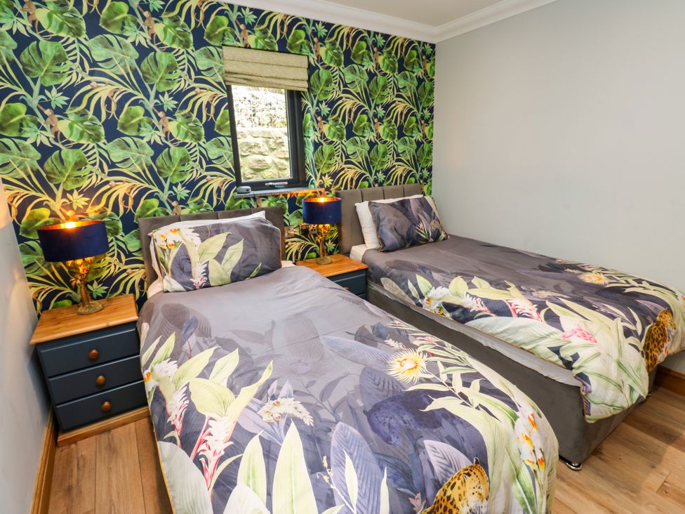 A bedroom with two beds and lamps at Caesars Lodge in Houghton Bank near Heighington