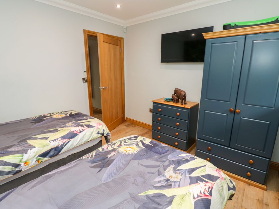 A bedroom with two beds and a television at Caesars Lodge Houghton Bank near Heighington