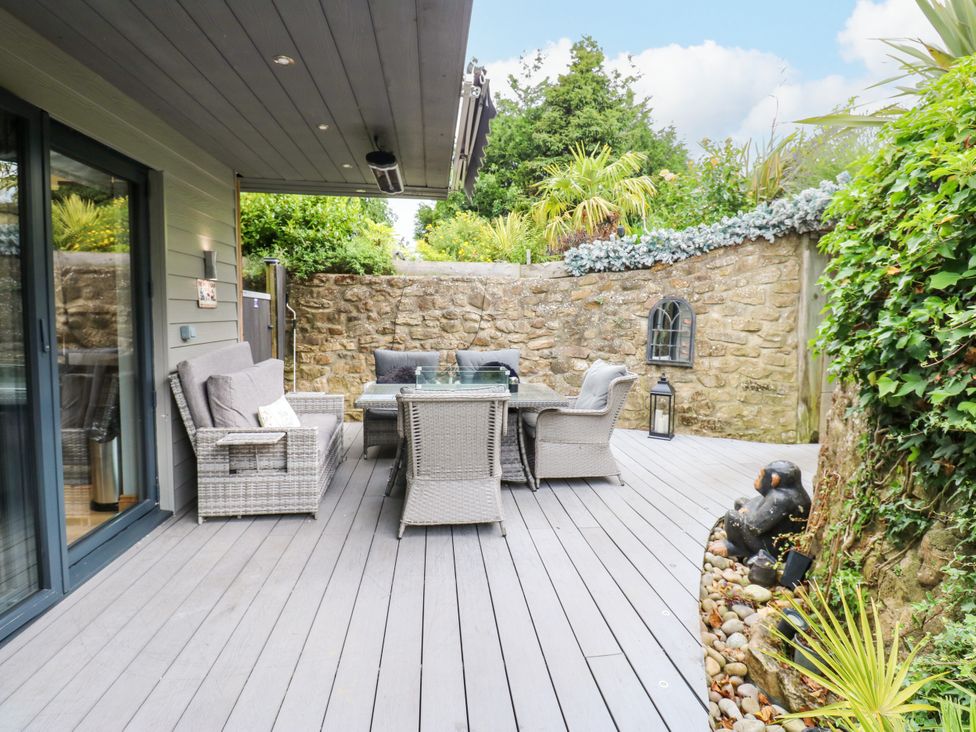 An outdoor patio with seating and stone wall at Caesars Lodge Houghton Bank near Heighington