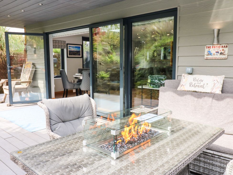 An outdoor patio with a fire pit and seating at Caesars Lodge Houghton Bank near Heighington