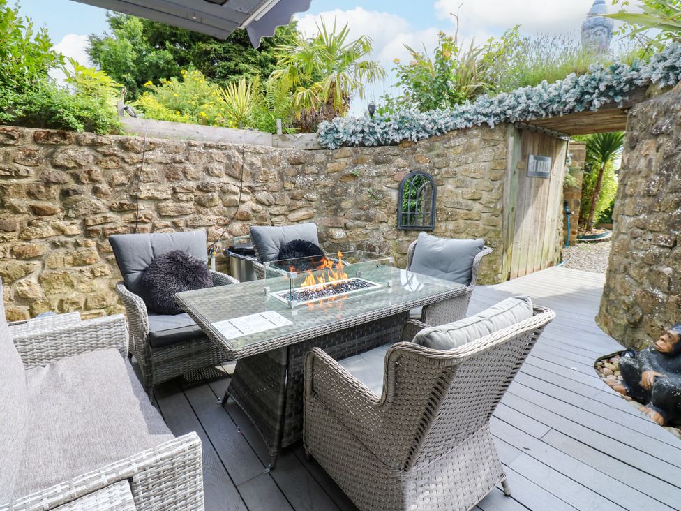 A garden with seating around a table and a fire pit at Caesars Lodge Houghton Bank near Heighington