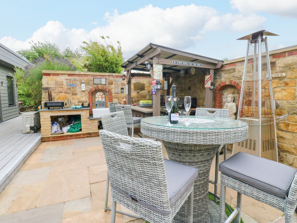 An outdoor dining area with a table and chairs at Caesars Lodge Houghton Bank near Heighington
