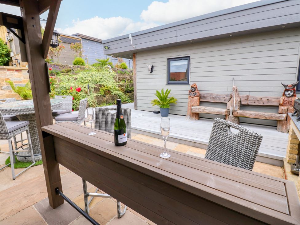 An outdoor seating area with a bottle of champagne at Caesars Lodge in Houghton Bank near Heighington
