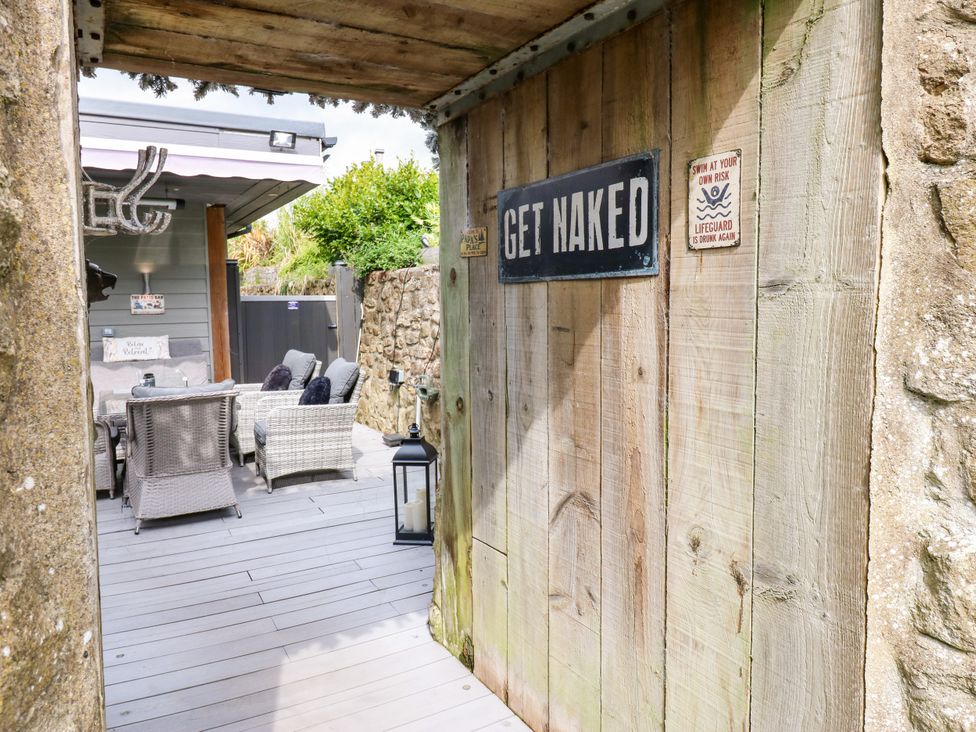 An outdoor area with seating and a wooden sign at Caesars Lodge in Houghton Bank near Heighington