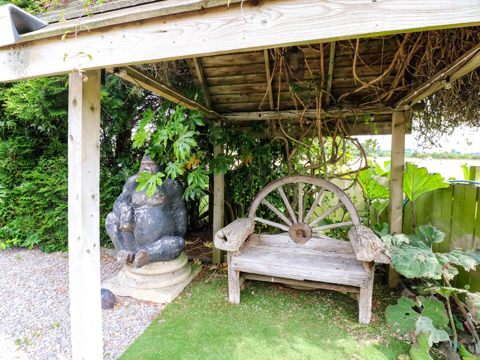 An outdoor area with a gorilla statue and a wooden bench at Caesars Lodge in Houghton Bank near Heighington