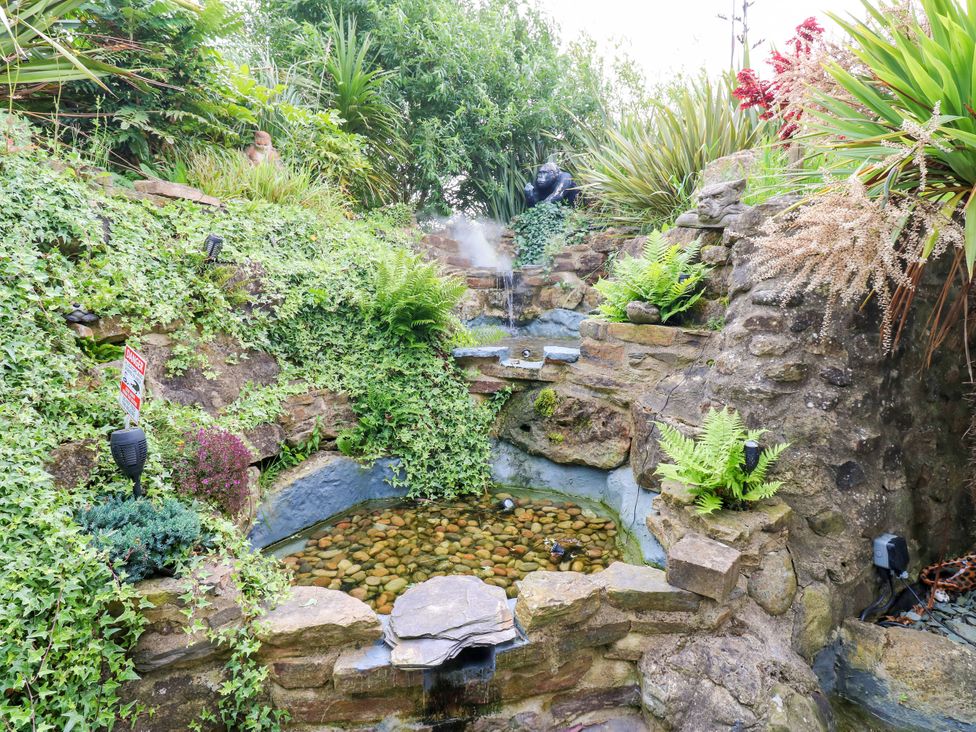A water feature with stones and plants in the garden at Caesars Lodge Houghton Bank near Heighington
