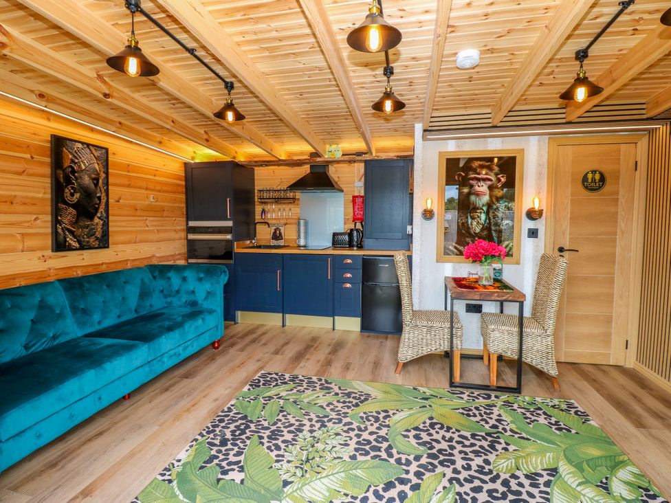A living room with a kitchen area and dining set at Black River in Houghton Bank near Heighington
