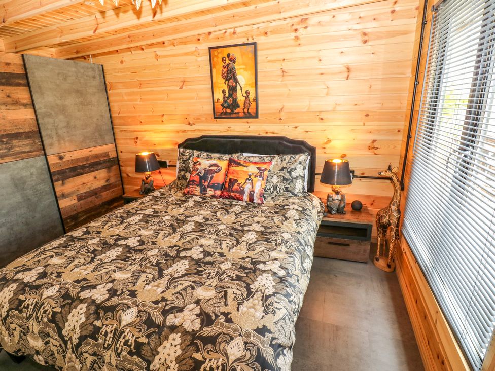 A bedroom with a bed and artwork on the walls at Black River in Houghton Bank near Heighington