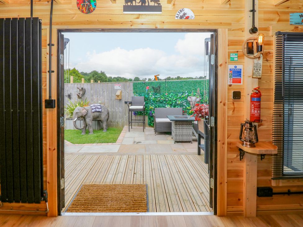 A view from inside showing a patio with furniture and elephant statues at Black River in Houghton Bank near Heighington