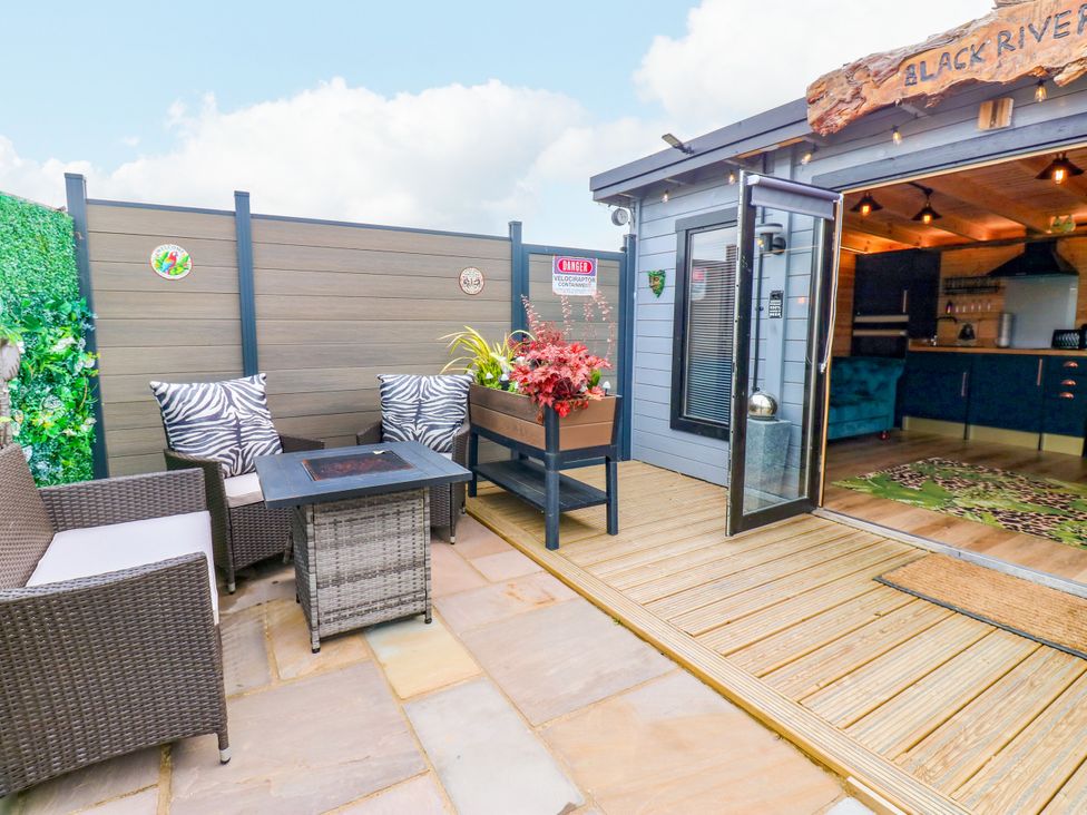 A patio area with outdoor seating and a table at Black River in Houghton Bank near Heighington