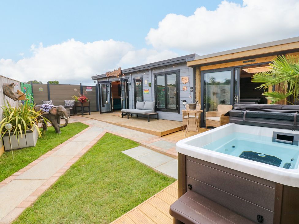 An outdoor area with a hot tub and wooden deck at Black River, Houghton Bank near Heighington