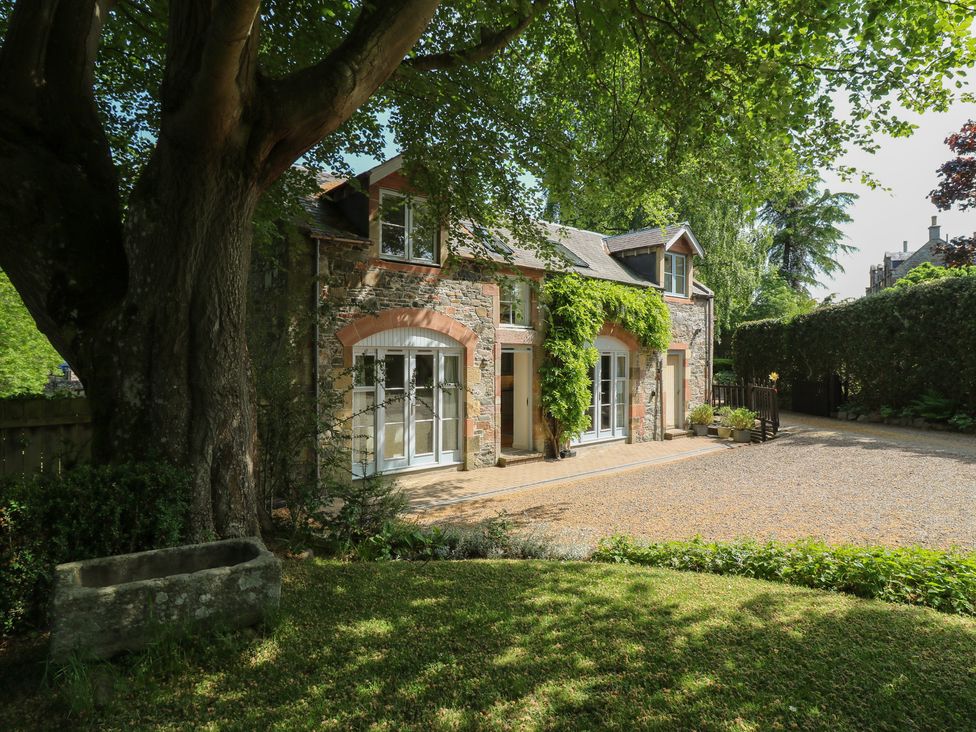 A building with windows and a front door surrounded by trees and pathway at Hollybank Barn near Melrose