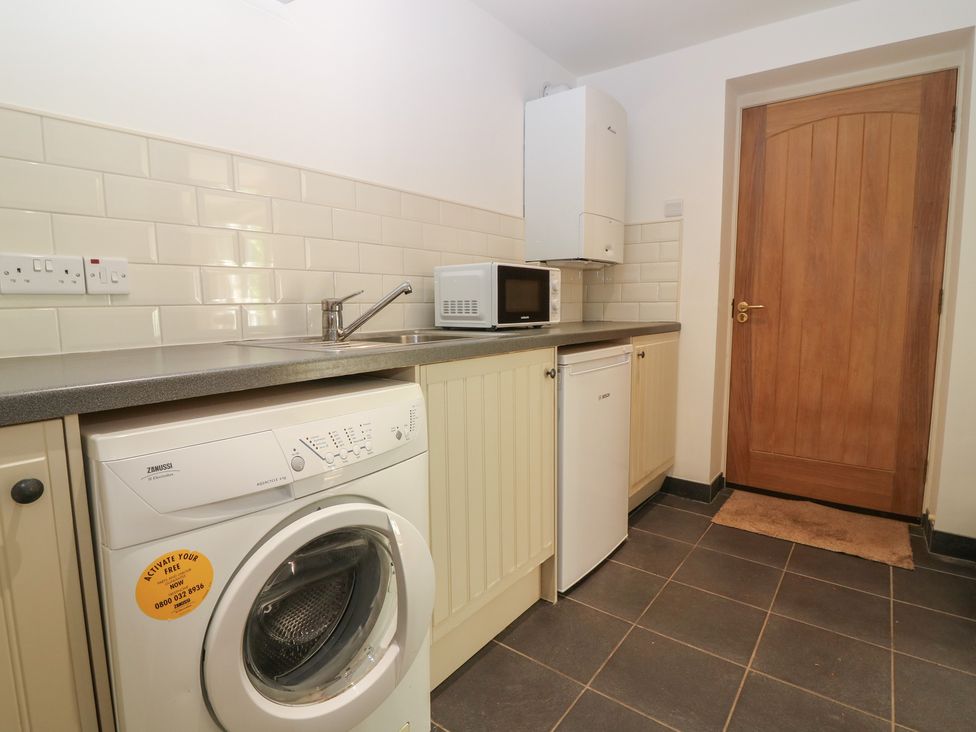 A laundry room with a washing machine and a microwave at Hollybank Barn near Melrose