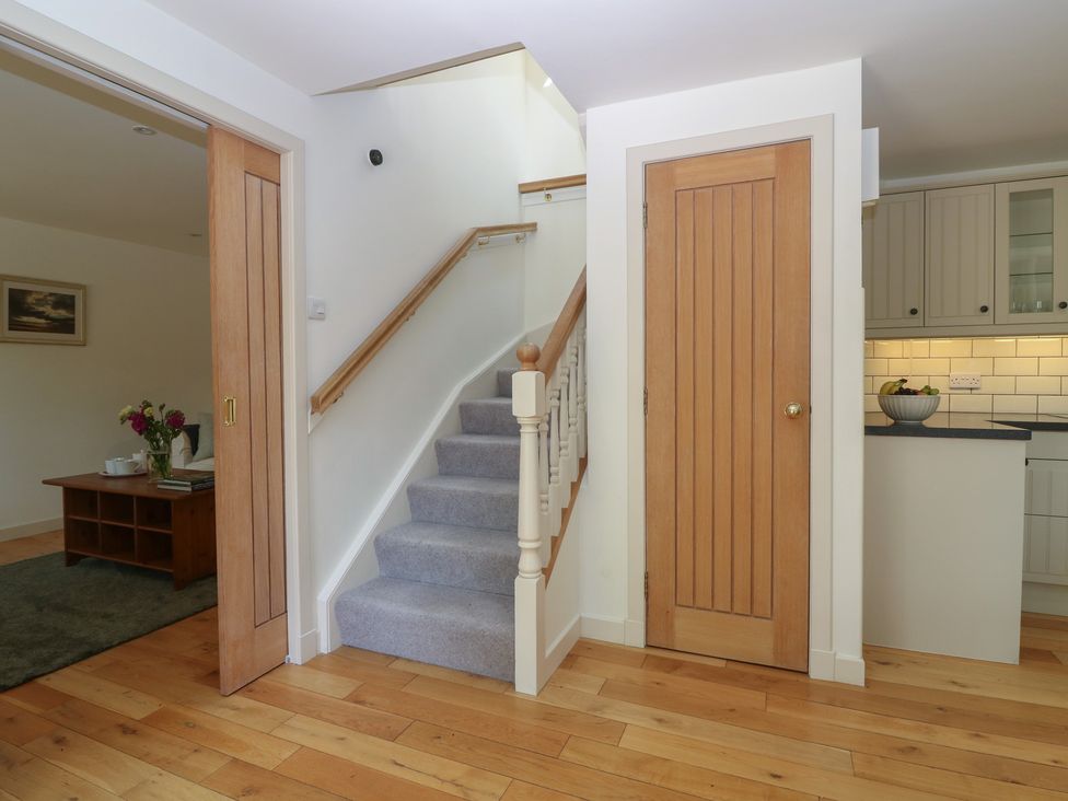 A hallway with a staircase and a door at Hollybank Barn near Melrose