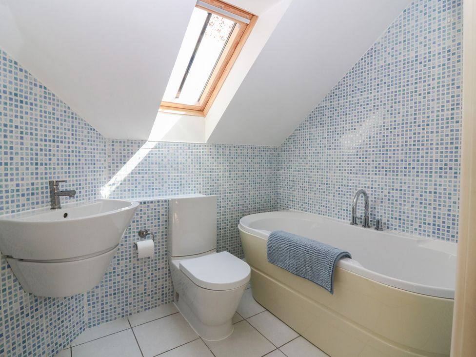 A bathroom with a bathtub, toilet, and sink at Hollybank Barn near Melrose