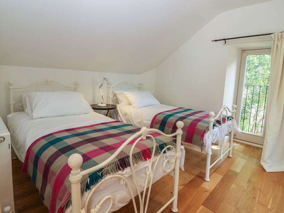 A bedroom with two beds and a door at Hollybank Barn near Melrose