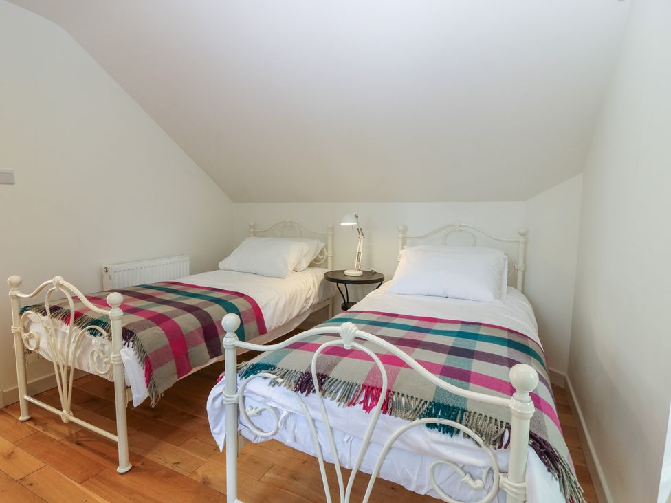 A bedroom with two beds and a bedside table at Hollybank Barn near Melrose