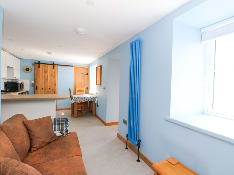A living room with a sofa and table at Post Cottage in Arisaig