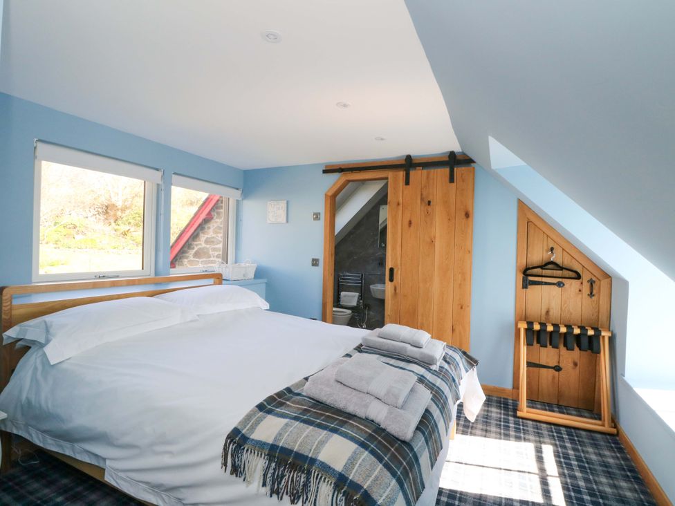 A bedroom with a bed and towels at Post Cottage in Arisaig