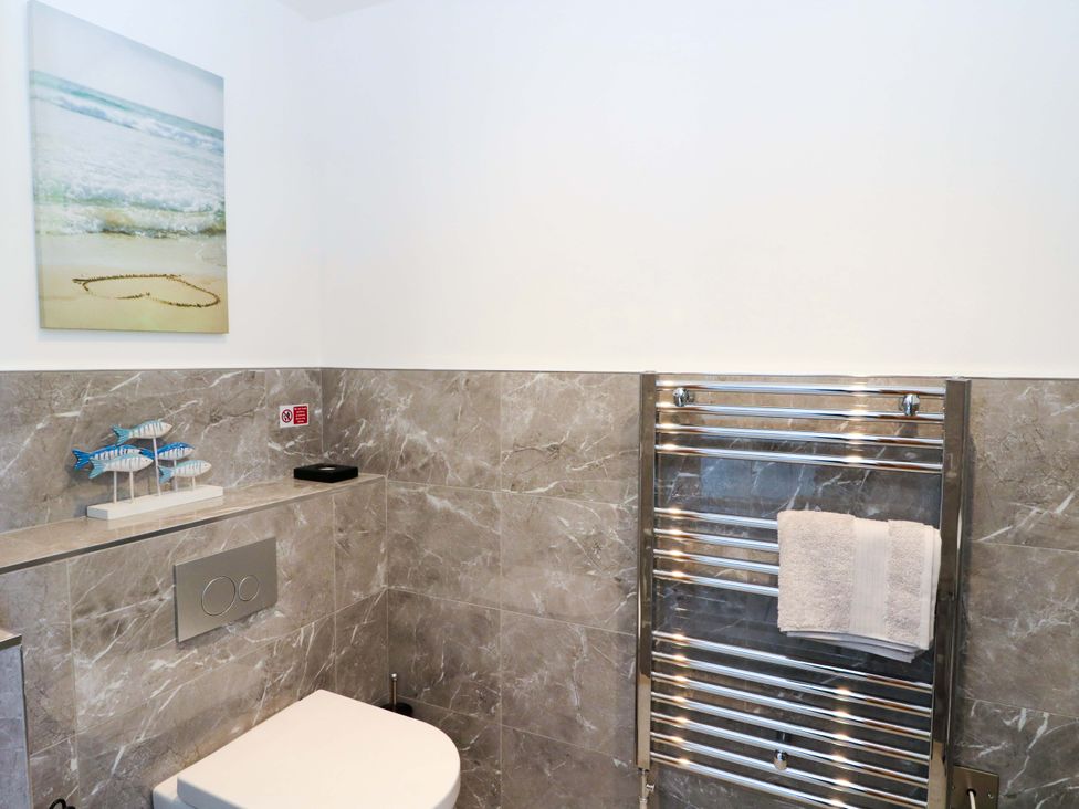 A bathroom with a toilet and towel rail at Post Cottage Arisaig