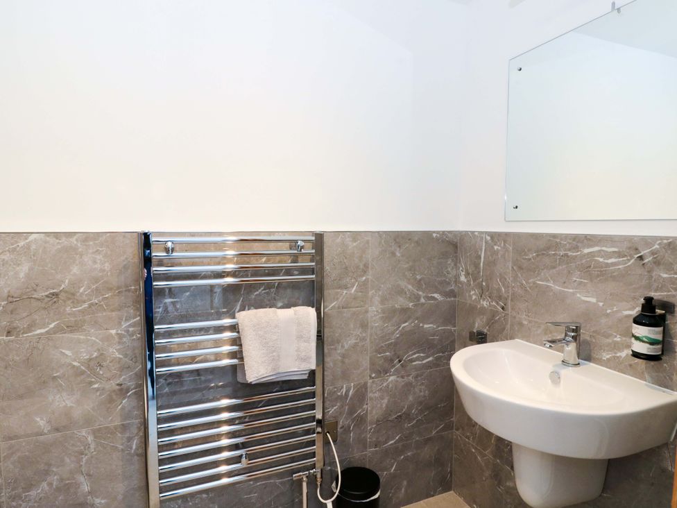 A bathroom with a towel radiator and sink at Post Cottage in Arisaig