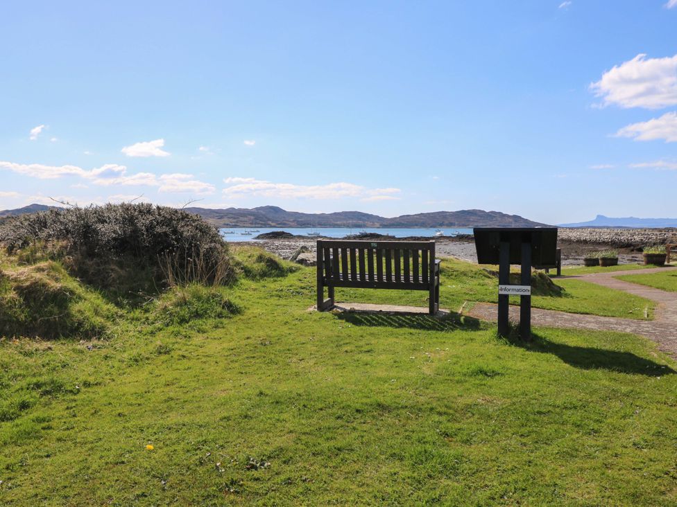 A bench and information sign overlooking the coast at Post Cottage in Arisaig