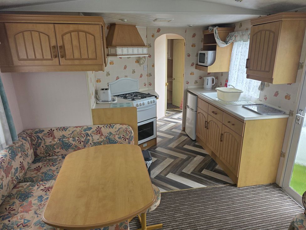 A kitchen with cabinets and appliances at Number 186 Owens Caravan Park, Abergele