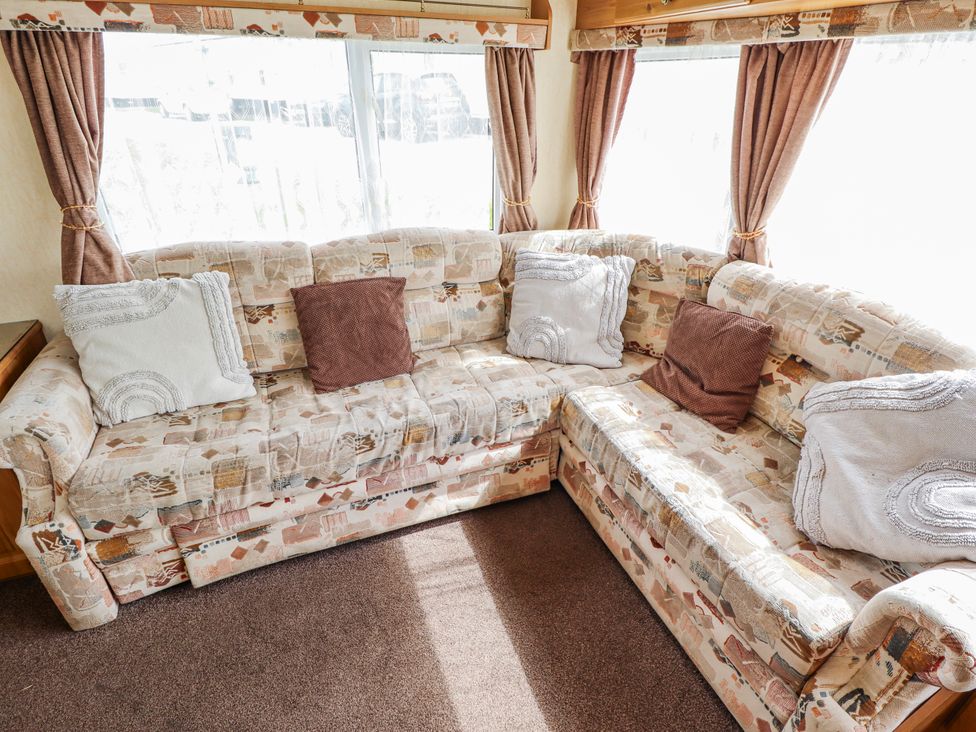 A sofa with cushions in a living room at Caravan 25 Skegness