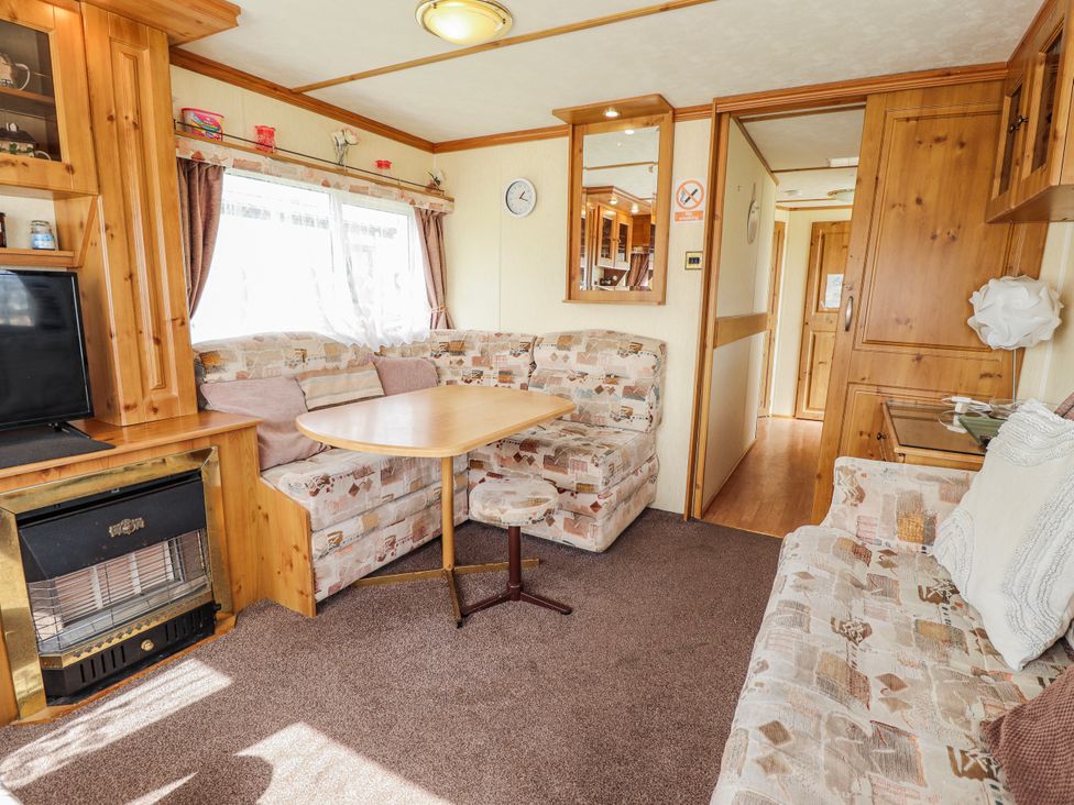 A living room with a sofa and table at Caravan 25 in Skegness