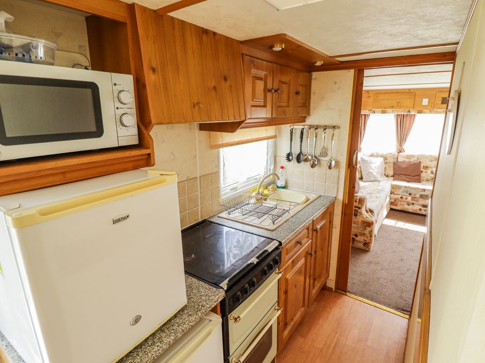 A kitchen with appliances and utensils at Caravan 25 in Skegness