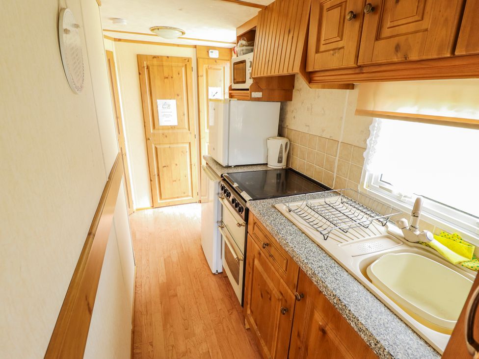 A kitchen with appliances and storage at Caravan 25 in Skegness