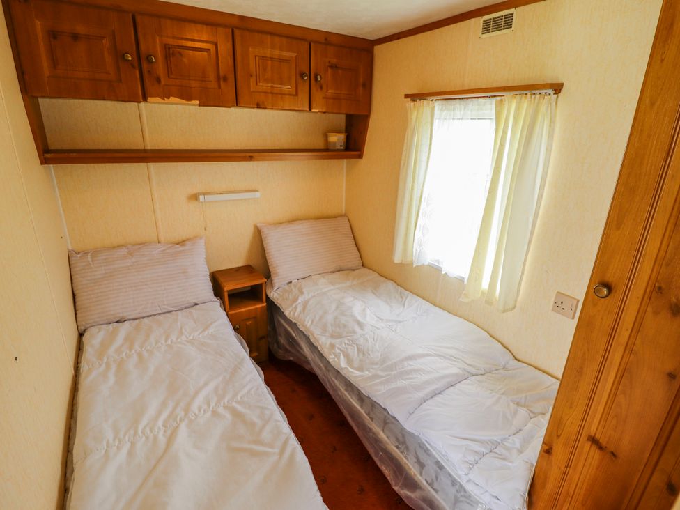 A bedroom with two beds and a window at Caravan 25 in Skegness