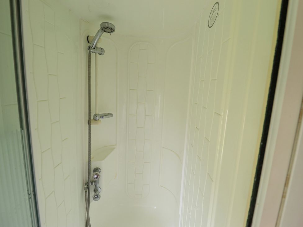 A shower with a showerhead and controls at Caravan 25 in Skegness