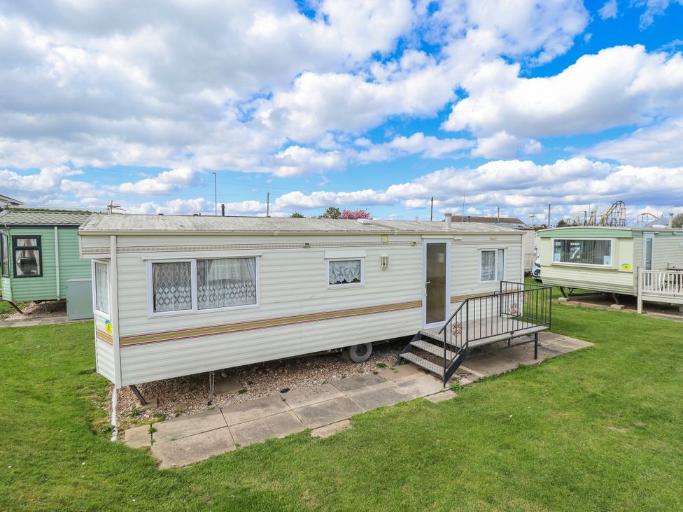 A caravan with steps and grass area at Caravan 25 in Skegness