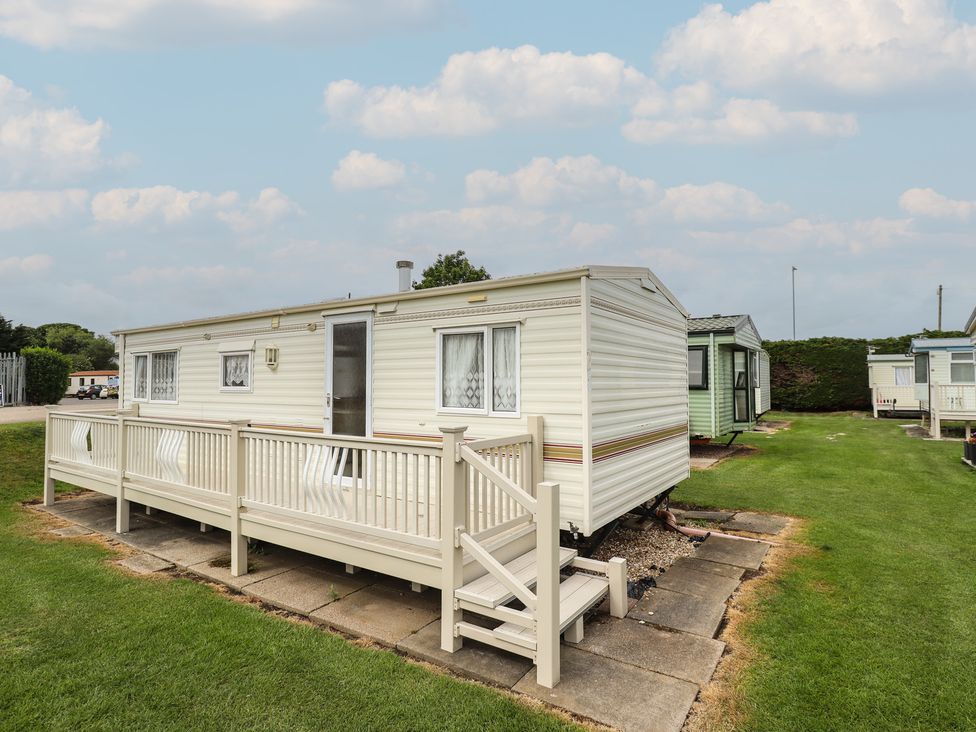 A caravan with decking and steps in an outdoor area at Caravan 25 Ingoldmells