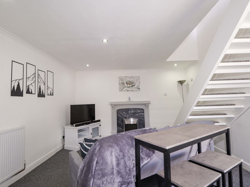 A living room with a sofa and television at 4A Carny Street in Macduff