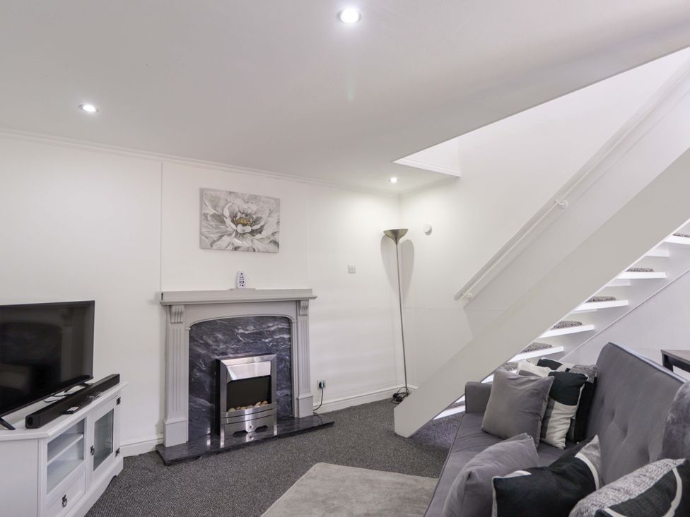 A living room with a sofa and a fireplace at 4A Carny Street Macduff