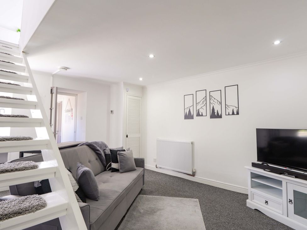 A living room with a sofa and television at 4A Carny Street, Macduff