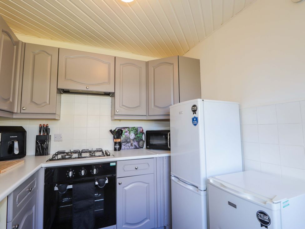 A kitchen with appliances and cabinets at 4A Carny Street in Macduff