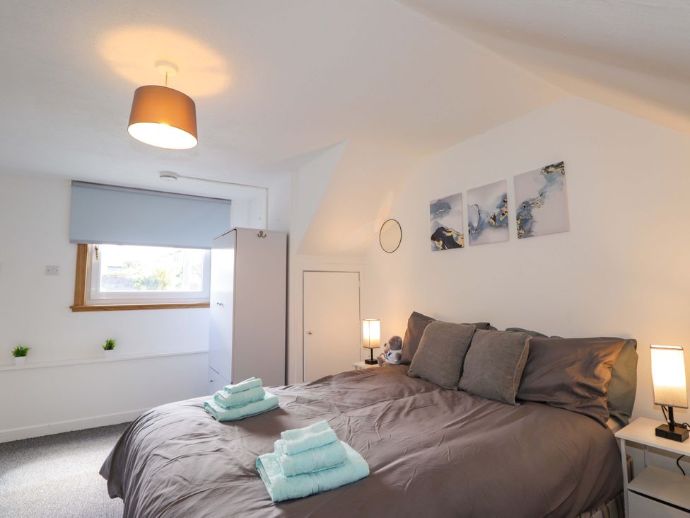 A bedroom with a bed and wardrobe at 4A Carny Street Macduff