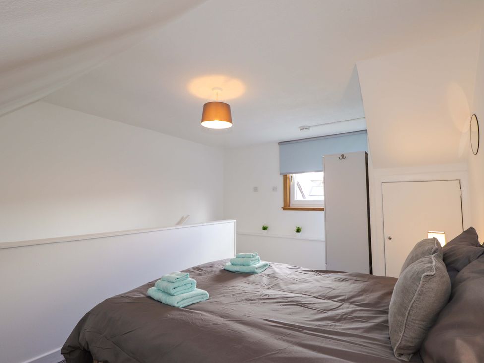 A bedroom with a bed and towels at 4A Carny Street in Macduff