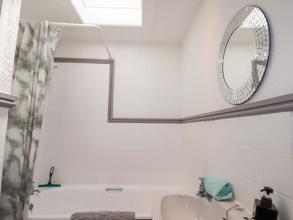 A bathroom with a bathtub and sink at 4A Carny Street in Macduff