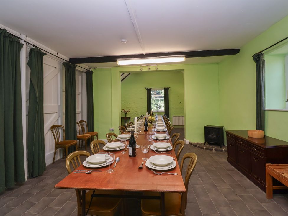 A dining room with a long table and chairs at The Old Stables in Gloucester
