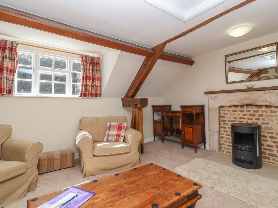 A living room with wooden furniture and a fireplace at The Old Stables in Gloucester
