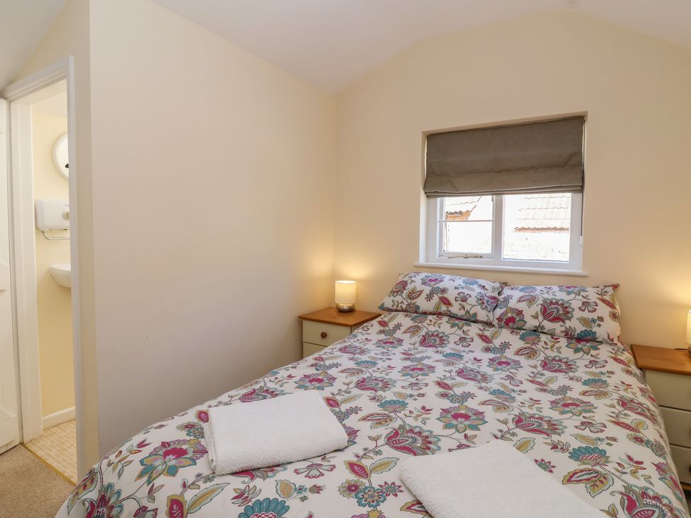 A bedroom with a bed and lamps at The Old Stables in Gloucester