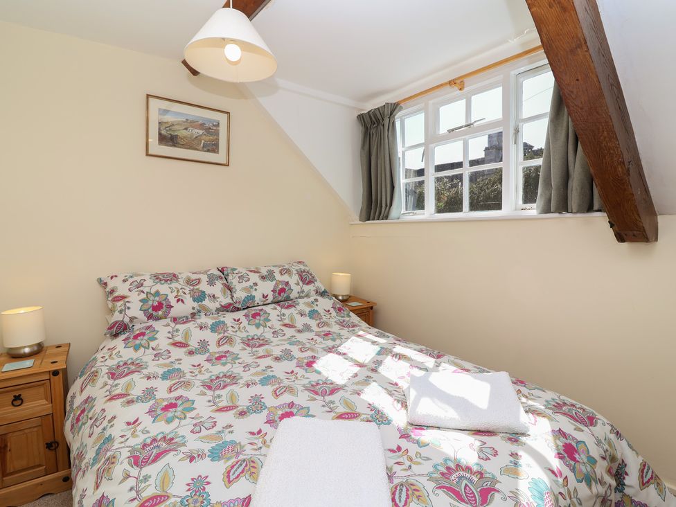 A bedroom with a bed and window at The Old Stables in Gloucester