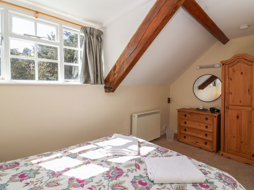 A bedroom with a bed and wardrobe at The Old Stables in Gloucester